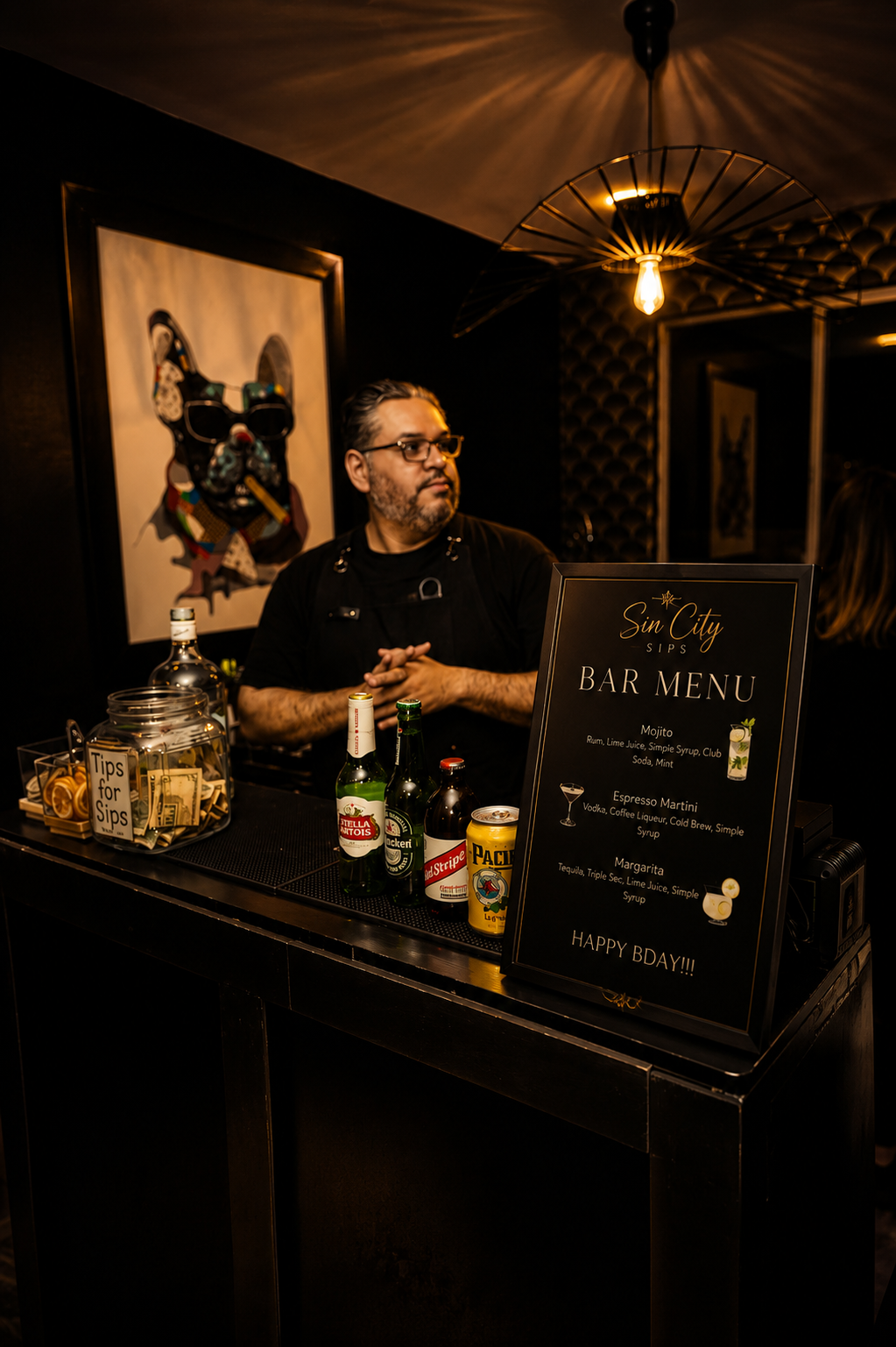 Sin City Sips bartender behind a custom bar menu setup at an event